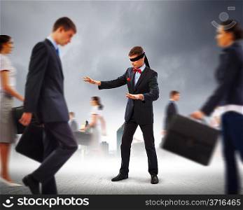 Businessman in blindfold among group of people