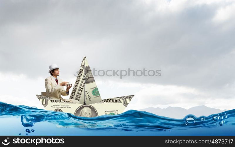 Businessman in boat made of dollar banknote. Successful businessman sailing on dollar boat in financial sea