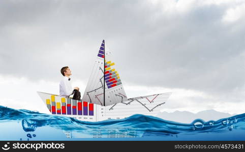 Businessman in boat made of paper. Successful businessman sailing on paper boat in financial sea