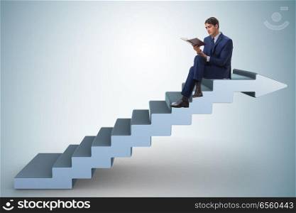 Businessman in career ladder concept reading book