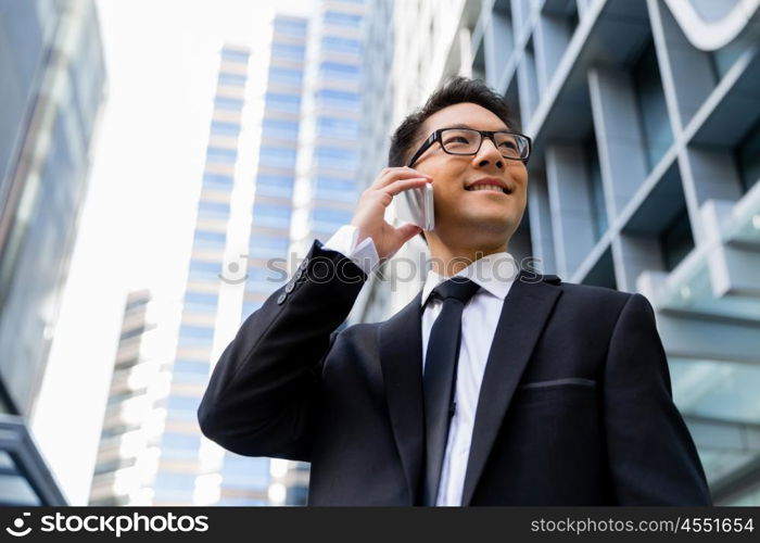 Businessman in city holding his mobile. I am always in touch with ny company