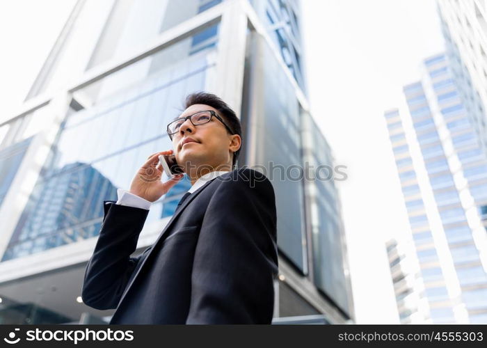 Businessman in city holding his mobile. I am always in touch with ny company