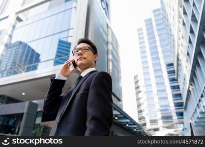 Businessman in city holding his mobile. I am always in touch with ny company