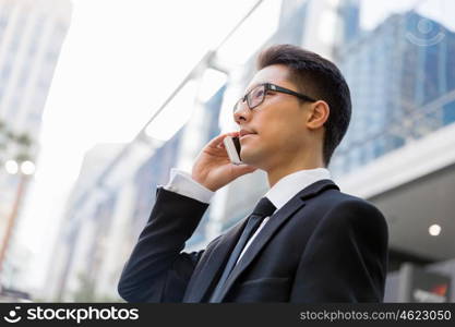 Businessman in city holding his mobile. I am always in touch with ny company