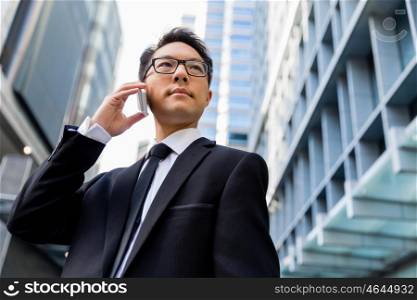 Businessman in city holding his mobile. I am always in touch with ny company