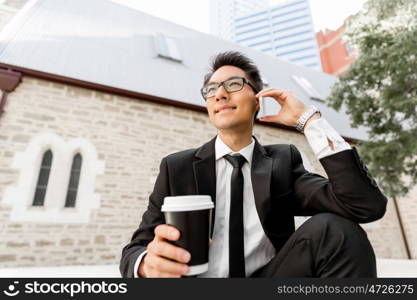 Businessman in city holding his mobile. I am always in touch with ny company