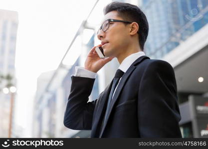 Businessman in city holding his mobile. I am always in touch with ny company