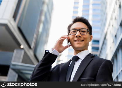 Businessman in city holding his mobile. I am always in touch with ny company