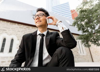 Businessman in city holding his mobile. I am always in touch with ny company