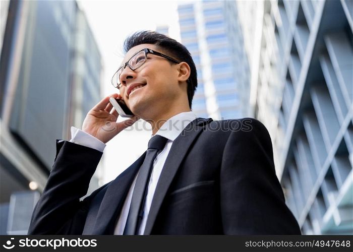 Businessman in city holding his mobile. I am always in touch with ny company