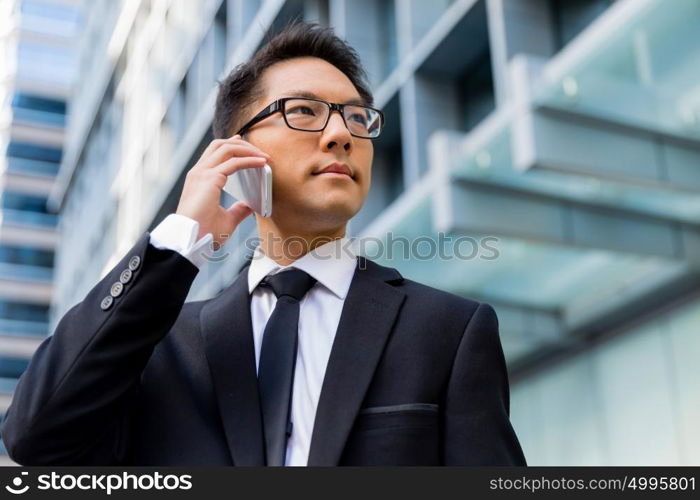 Businessman in city holding his mobile. I am always in touch with ny company