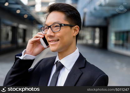 Businessman in city holding his mobile. I am always in touch with ny company