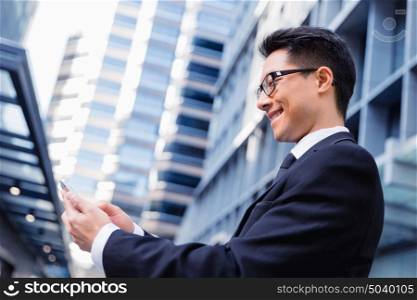 Businessman in city holding his mobile. Technology is a part of my life