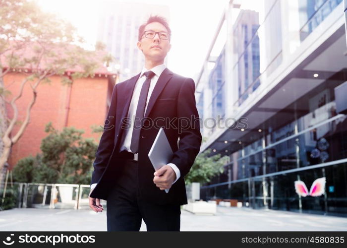 Businessman in city holding his notebook. Technology is a part of my life