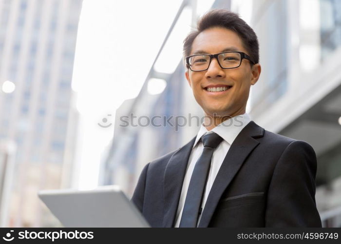 Businessman in city holding his notebook. Technology is a part of my life