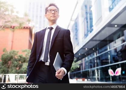 Businessman in city holding his notebook. Technology is a part of my life