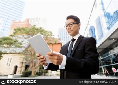 Businessman in city holding his notebook. Technology is a part of my life