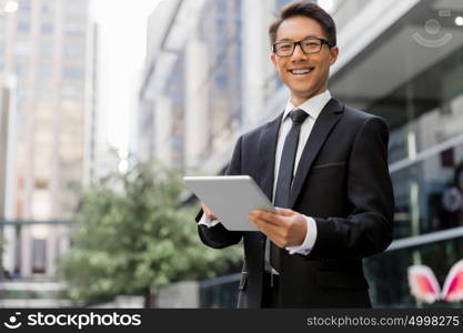 Businessman in city holding his notebook. Technology is a part of my life