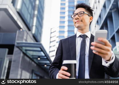 Businessman in city walking and holding his mobile. Technology is a part of my life