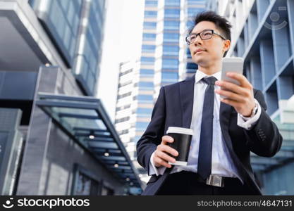 Businessman in city walking and holding his mobile. Technology is a part of my life