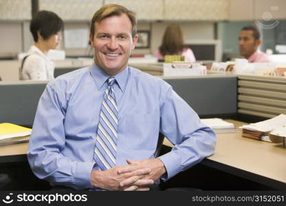 Businessman in cubicle smiling