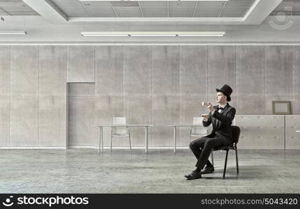 Businessman in cylinder drinking coffee. Businessman taking break at office and having cup of hot aromatic coffee