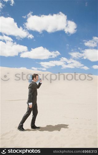 Businessman in desert with bottle