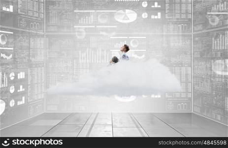 Businessman in empty room. Young businessman sitting on cloud in room and infographs on wall