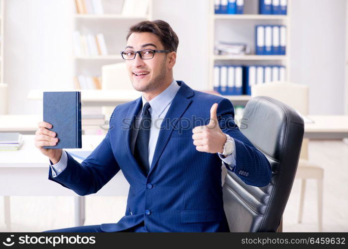 Businessman in executive education concept with book