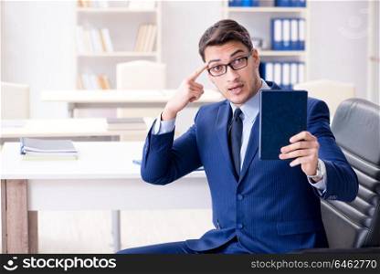 Businessman in executive education concept with book