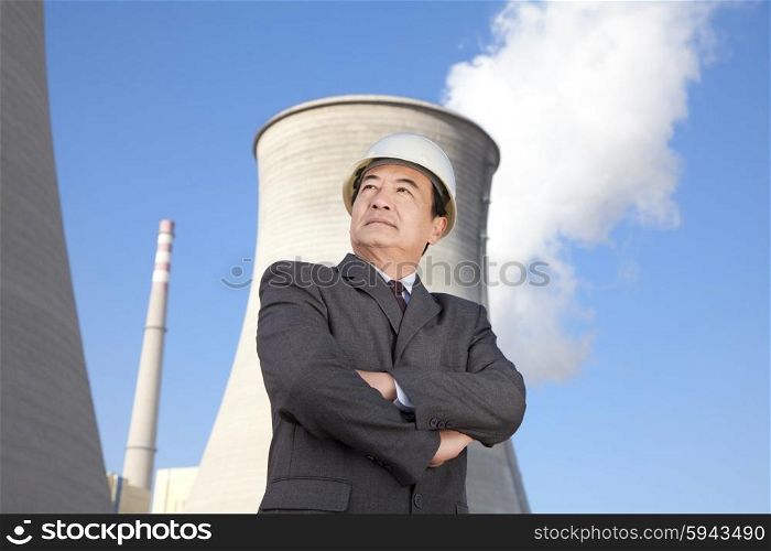 Businessman in front of cooling tower