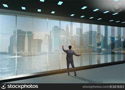 Businessman in front of office window thinking of new challenges