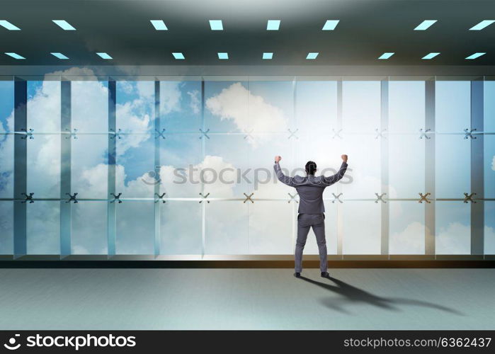 Businessman in front of office window thinking of new challenges. The businessman in front of office window thinking of new challenges