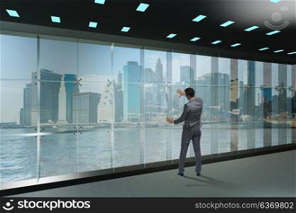 Businessman in front of office window thinking of new challenges