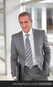 Businessman in grey suit standing in offices hall