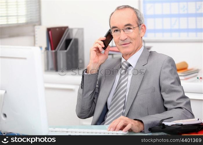 businessman in his office taking a call