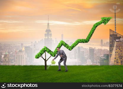 Businessman in investment concept watering financial line chart