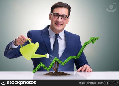 Businessman in investment concept watering financial line chart