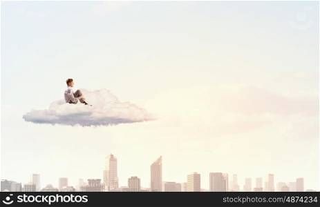 Businessman in isolation. Depressed young businessman sitting alone on cloud high in sky