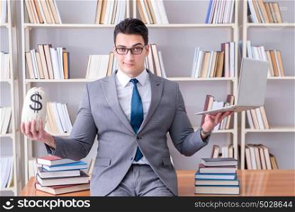 Businessman in library with a money sack and a laptop