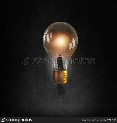 Businessman in light bulb. Businessman thinks inside of glowing light bulb