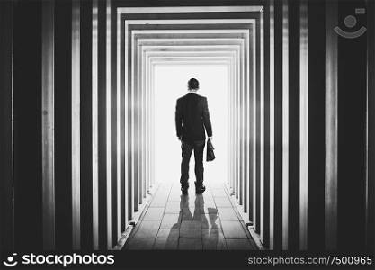 Businessman in line-shaped corridors and confused to exit the unknown bright door .