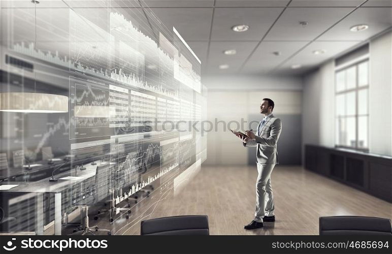 Businessman in modern interior mixed media. Busy businessman making notes and writing something in his organizer at his office