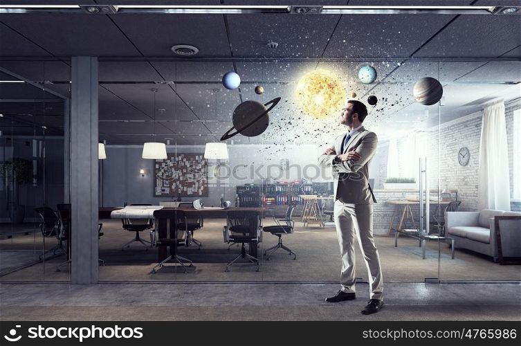 Businessman in modern office mixed media. Young elegant businessman in office thinking over busines