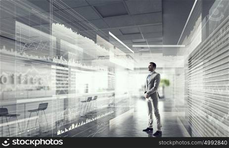 Businessman in modern office mixed media. Young elegant businessman in office thinking over business