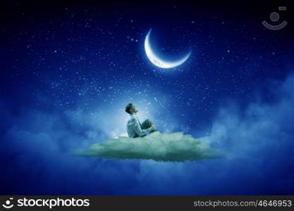 Businessman in night sky. Businessman in suit sitting on cloud in isolation and looking at moon