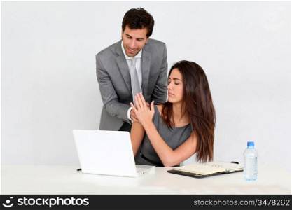 Businessman in office harassing young woman
