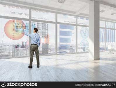 Businessman in office mixed media. Young successful businessman in white office interior