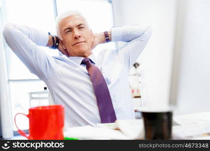 Businessman in office relaxing leaning back on chair. Few minutes to relax