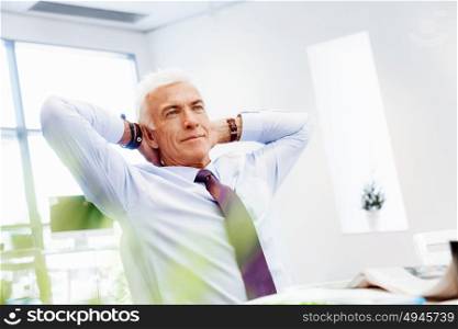 Businessman in office relaxing leaning back on chair. Few minutes to relax